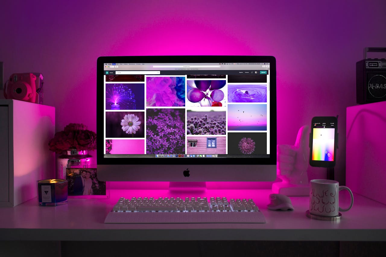our-story Modern desk setup with neon lighting and a desktop computer displaying colorful images.